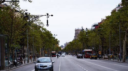 Free A bustling street view in Barcelona capturing urban transport and architecture. Stock Photo