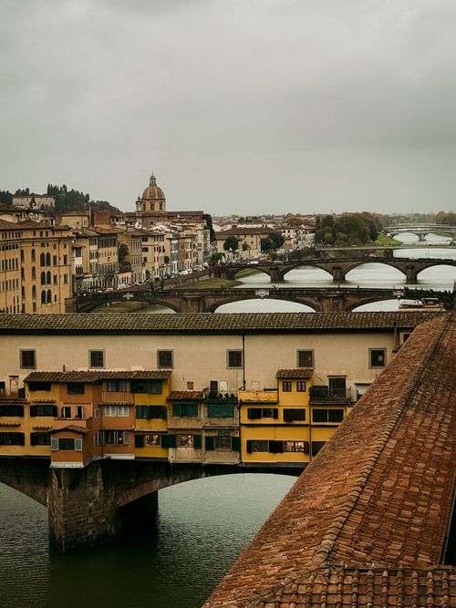 Free Elevated view of the iconic Ponte Vecchio in Florence, Italy, against a cloudy backdrop. Stock Photo