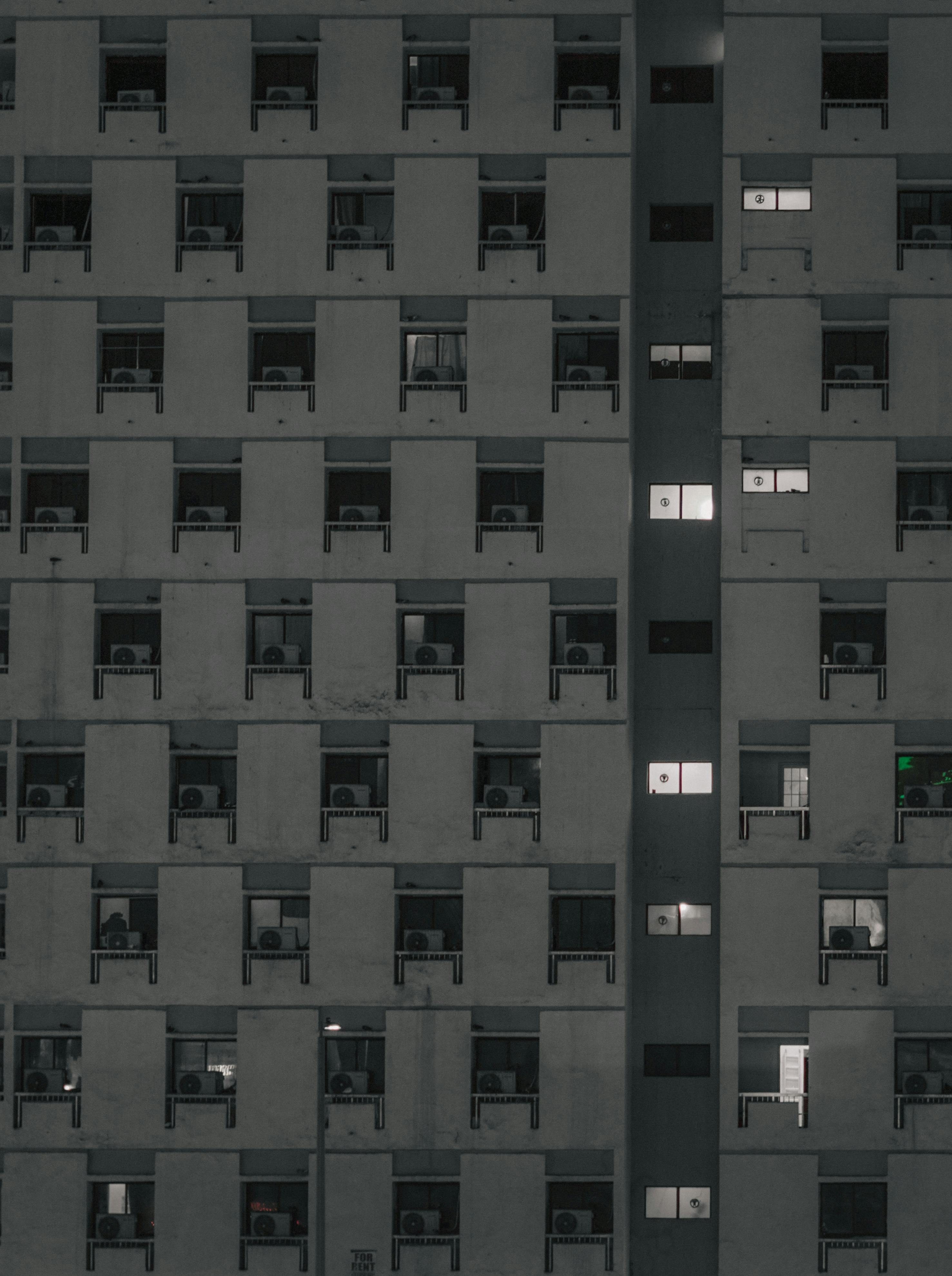 De franc Façana simètrica d'un edifici a Dubai, amb patrons geomètrics i finestres il·luminades. Foto d'estoc