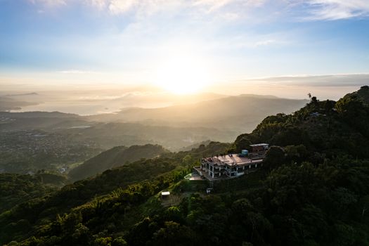 Stunning aerial view of sunrise illuminating lush hillsides in San Salvador, El Salvador.