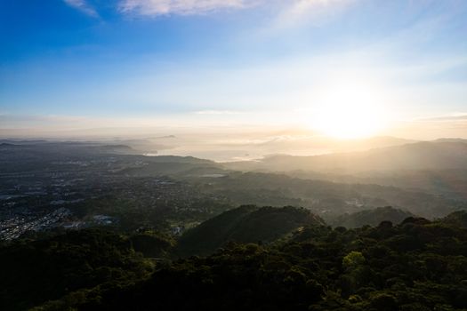 A breathtaking aerial view of San Salvador at sunrise, highlighting mountains and valleys.