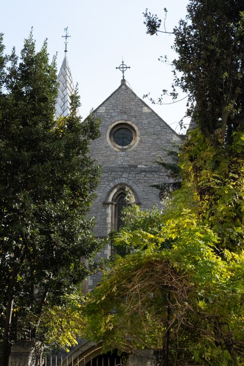 Free Charming church facade partially hidden by lush trees in Istanbul, Türkiye. Stock Photo