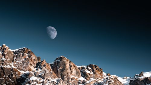 Free Stunning alpine scene in Laax with snow-capped peaks and moonlit sky. Stock Photo