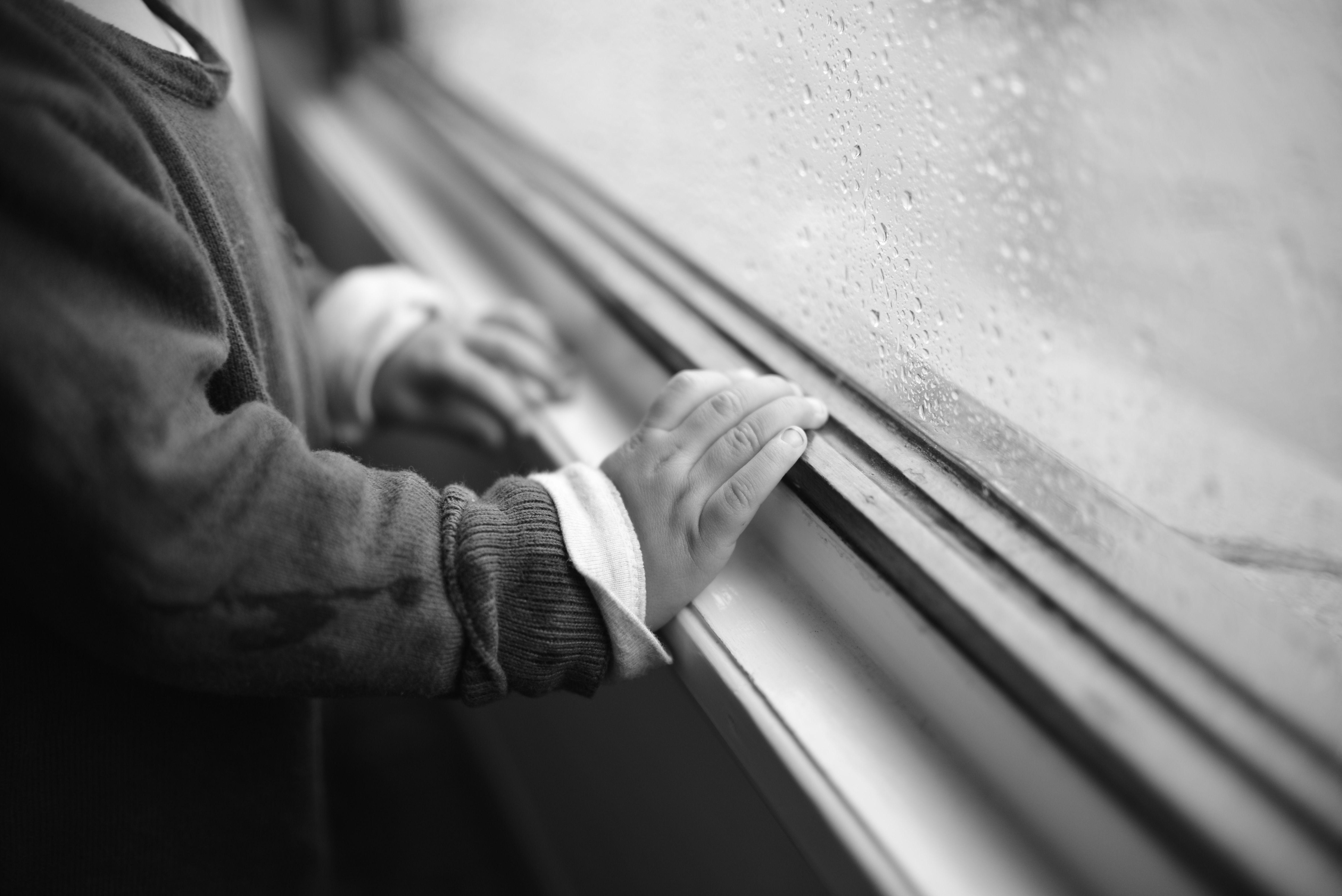 Παιδικό χέρι σε παράθυρο, συμβολική εικόνα για τη σιωπή και την απομόνωση