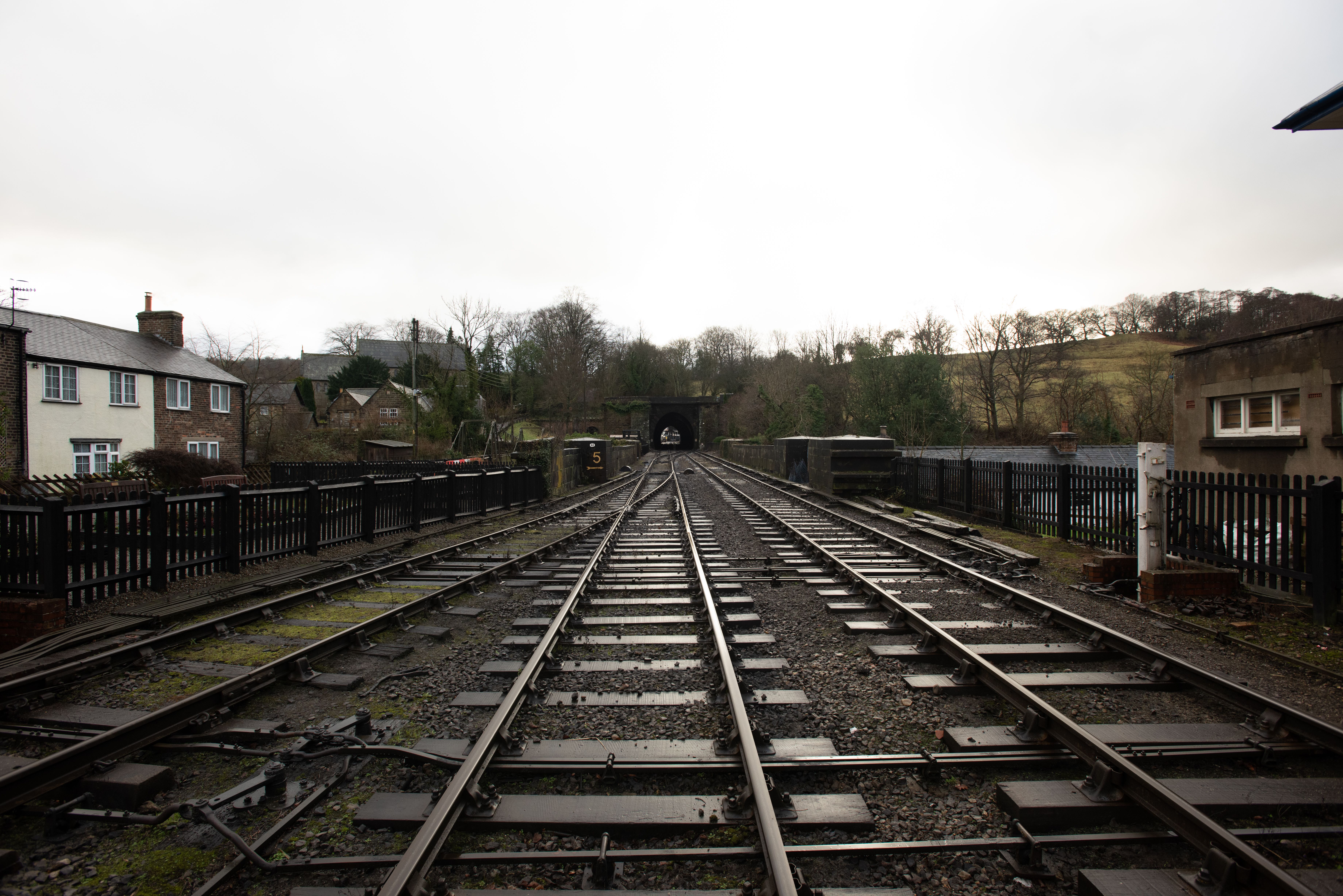 Railway tracks running through British countryside under overcast skies