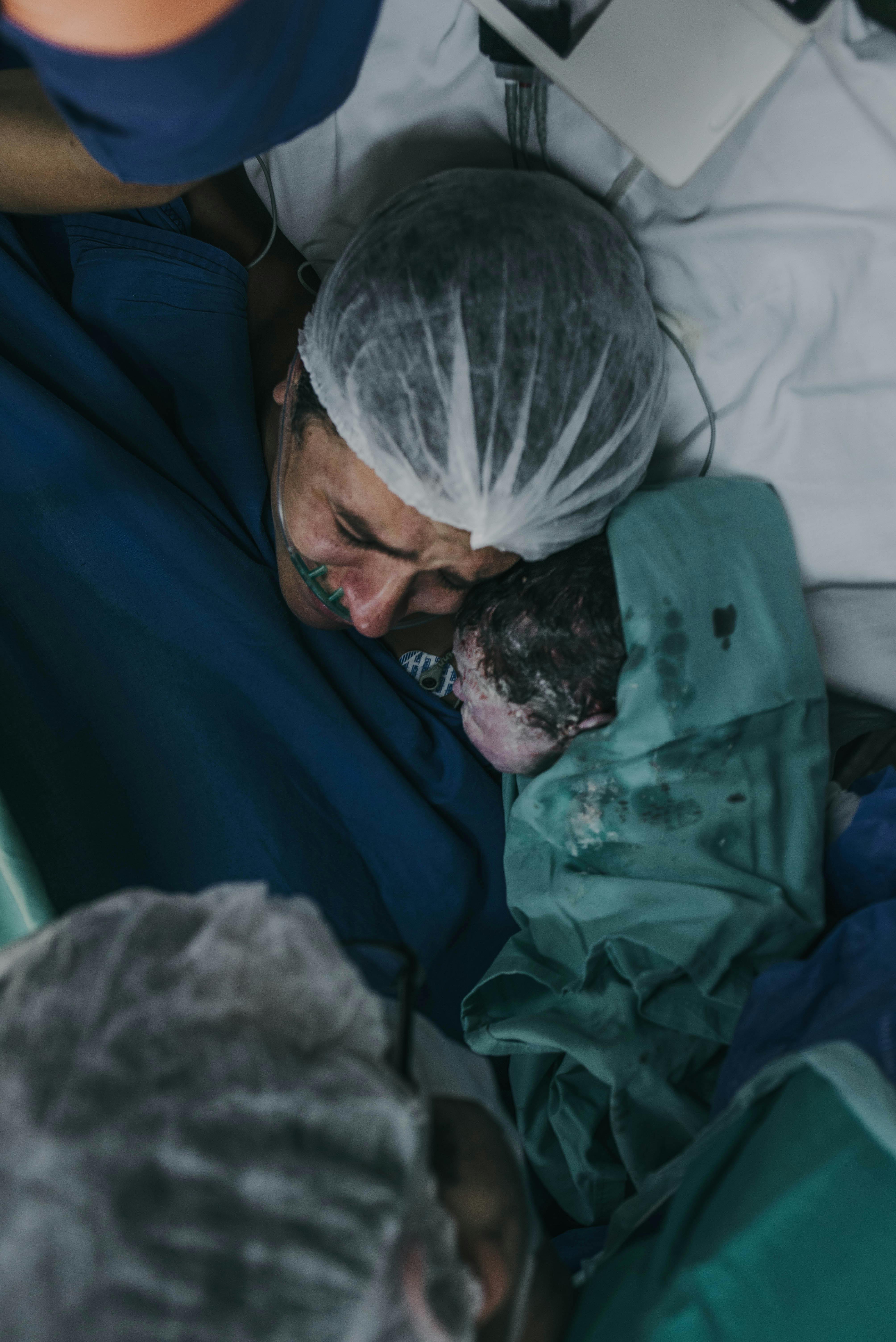 Mother first meets newborn in hospital, an intimate moment full of emotion.