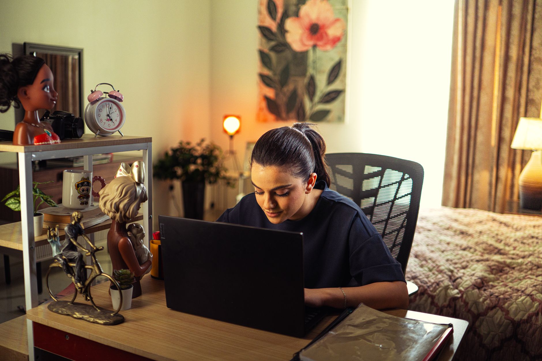 A coach working at a laptop in a home office in warm natural light
