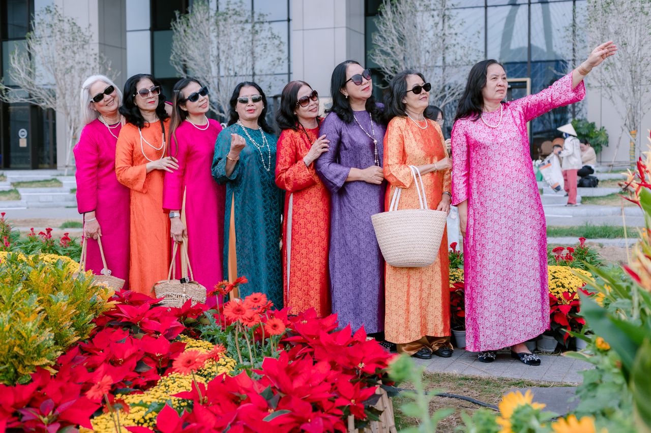 a group of women in colorful traditional dresses posing outdoors among