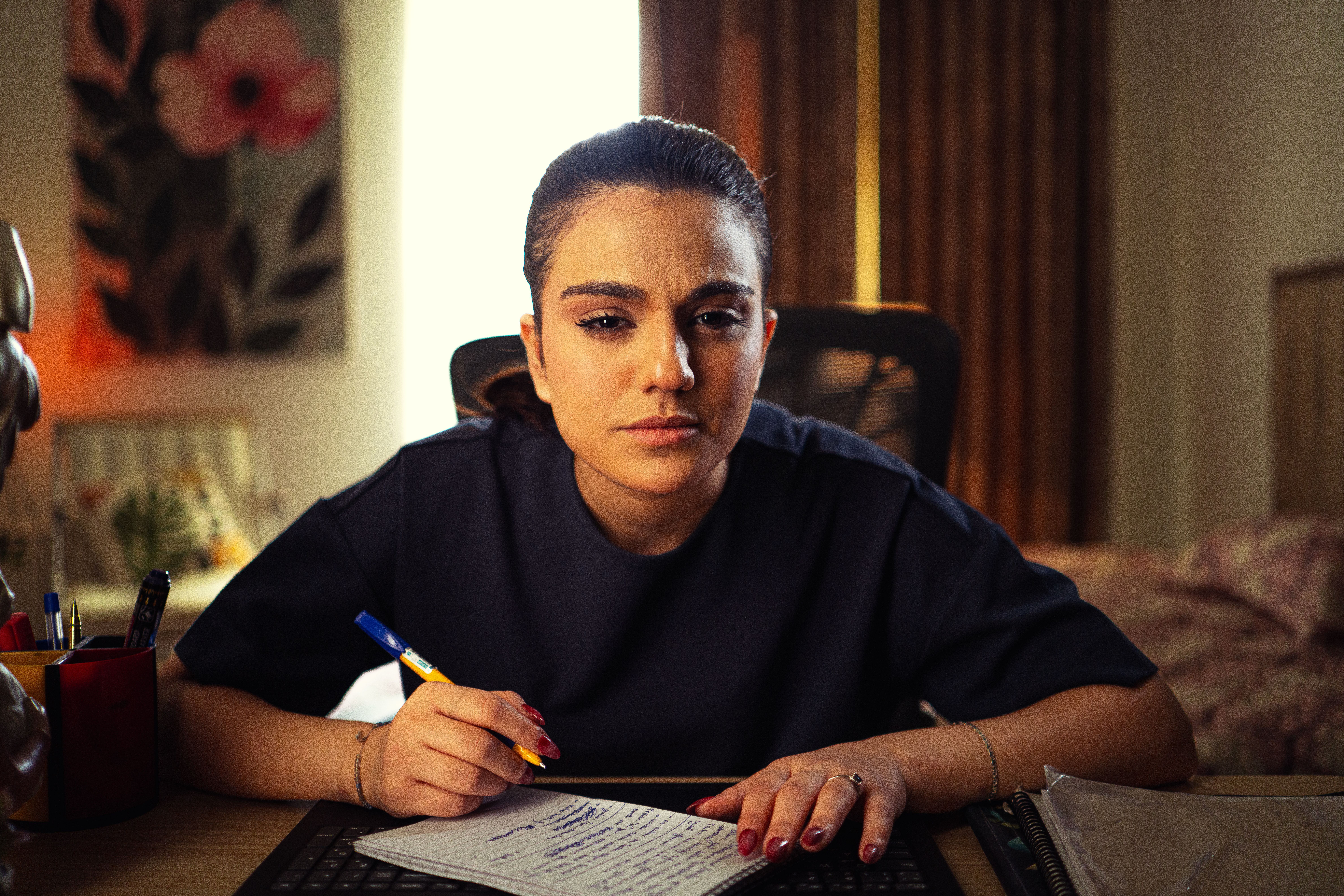 Young woman deeply focused while studying in a cozy home office setting.