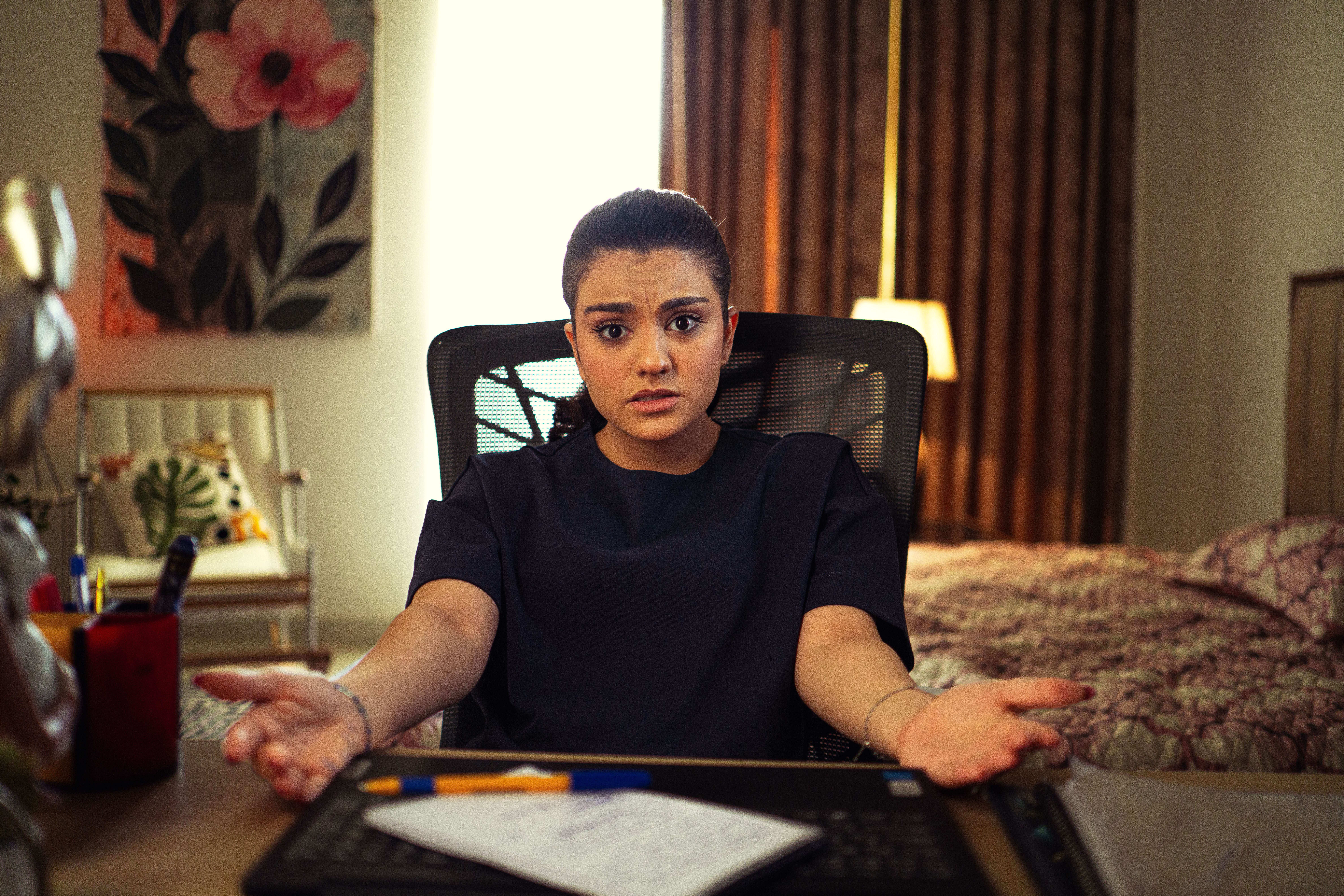 A frustrated woman at a desk, questioning the quality of her current seo content writing tool.