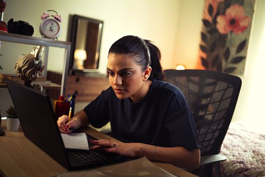 Zarabianie przez internet dla nastolatków: 5 legalnych sposobów w 2026 3 Young woman intensely studying on a laptop at a well-lit desk indoors.