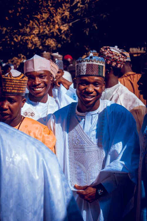 Free A lively outdoor celebration showing men in traditional attire with joyous expressions. Stock Photo