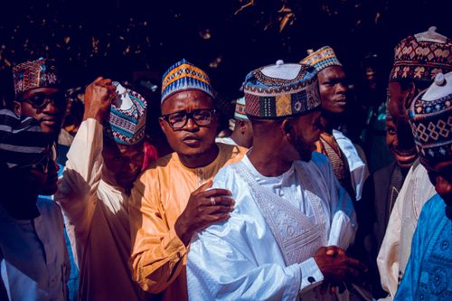 Free A vibrant cultural event with men in traditional clothing and hats. Stock Photo