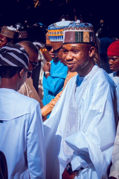 Free Men wearing traditional Nigerian attire gather for a cultural celebration outdoors, showcasing colorful and intricate clothing. Stock Photo