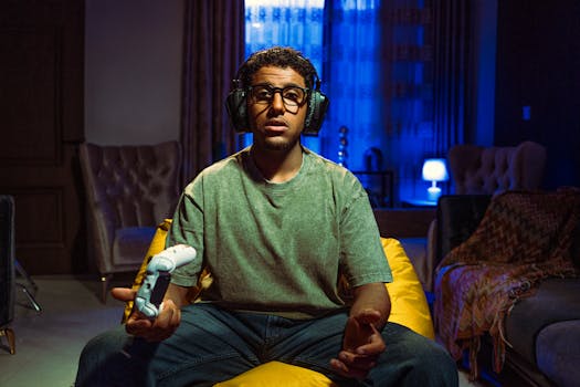 A man with headphones plays video games on a console in a cozy living room at night.