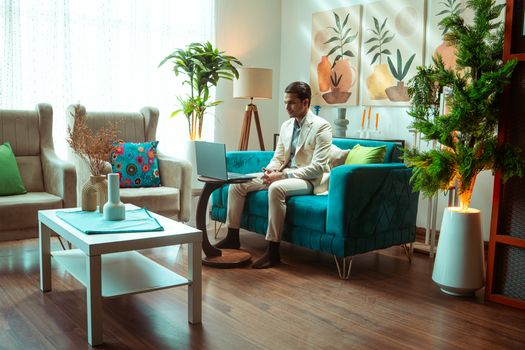 Stylish living room setup with a man working on a laptop, showcasing modern interior design.