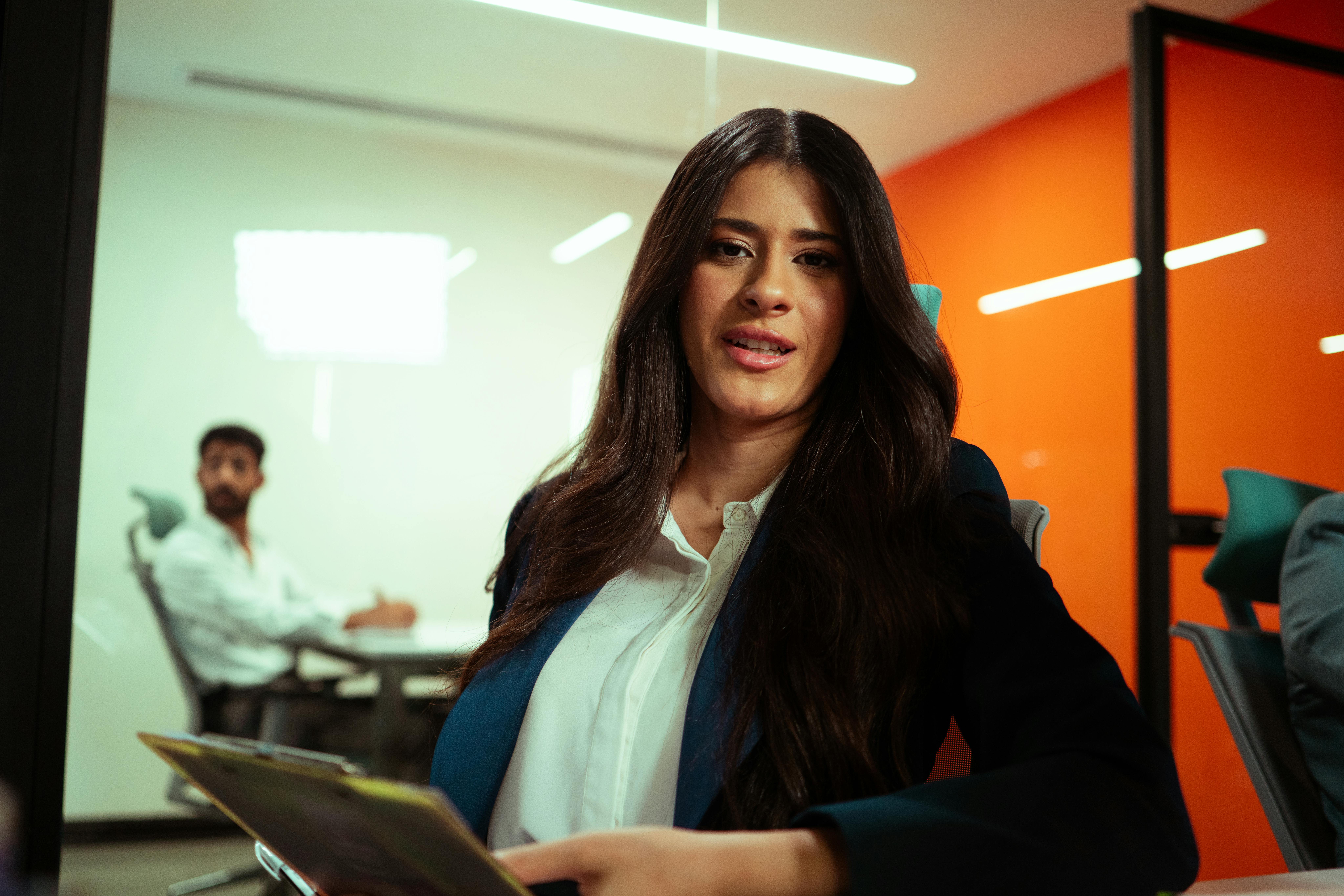 Professional woman in a modern office environment engaging in a business meeting.