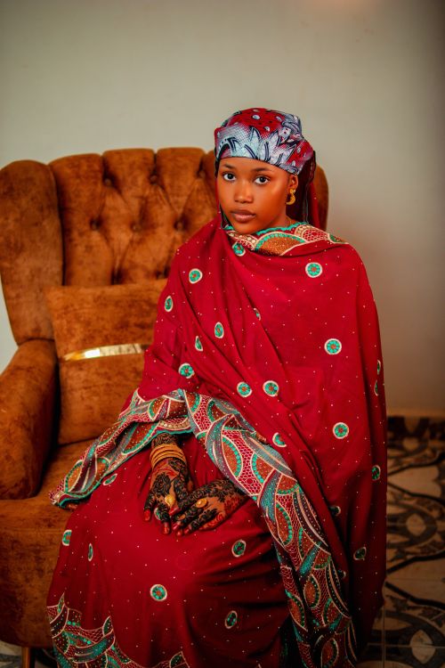 Free Beautiful portrait of a woman in vibrant traditional clothing seated indoors. Stock Photo