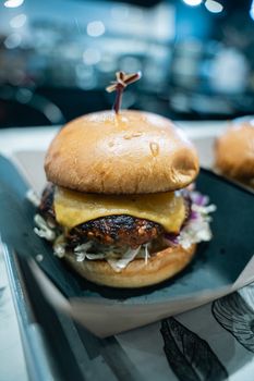Delicious beef cheeseburger with lettuce and cheese on a table.