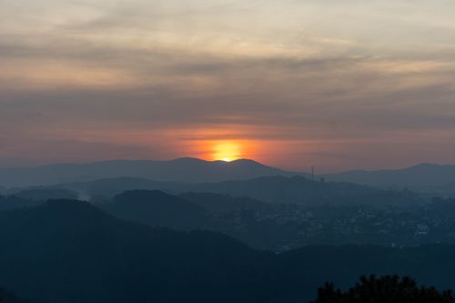 Free Majestic sunset over the misty hills of Dalat, Vietnam, casting a serene glow. Stock Photo