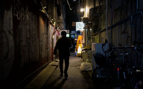 Free Silhouetted figure in a moody Osaka alleyway at night, showcasing urban ambiance. Stock Photo