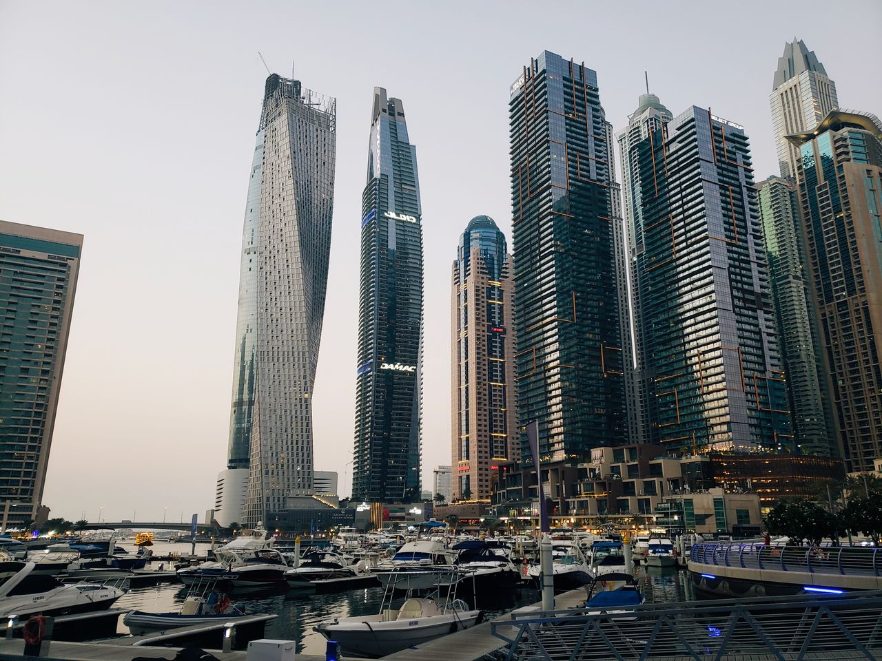 Stunning view of Dubai Marina at dusk with towering skyscrapers and luxury yachts.