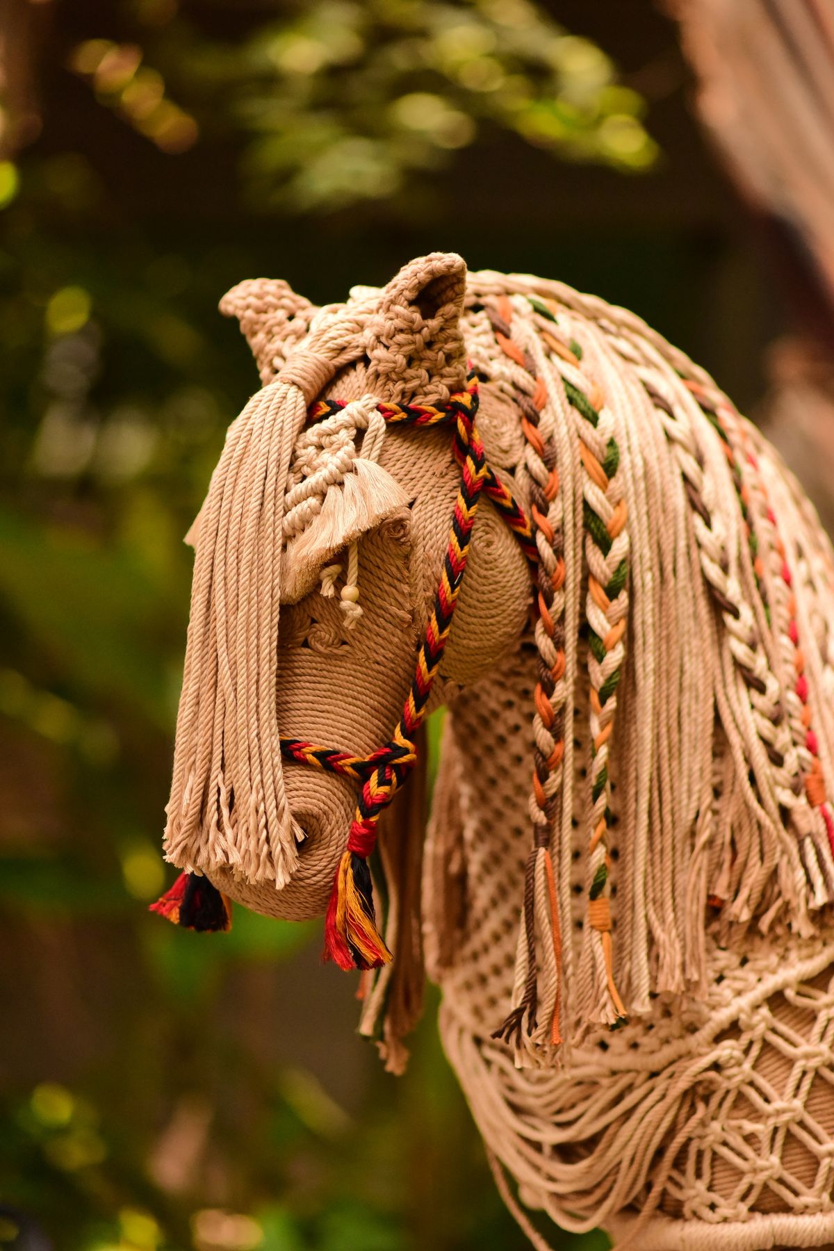 A braided textile horse with a woven mane, like a handmade felt pony plush