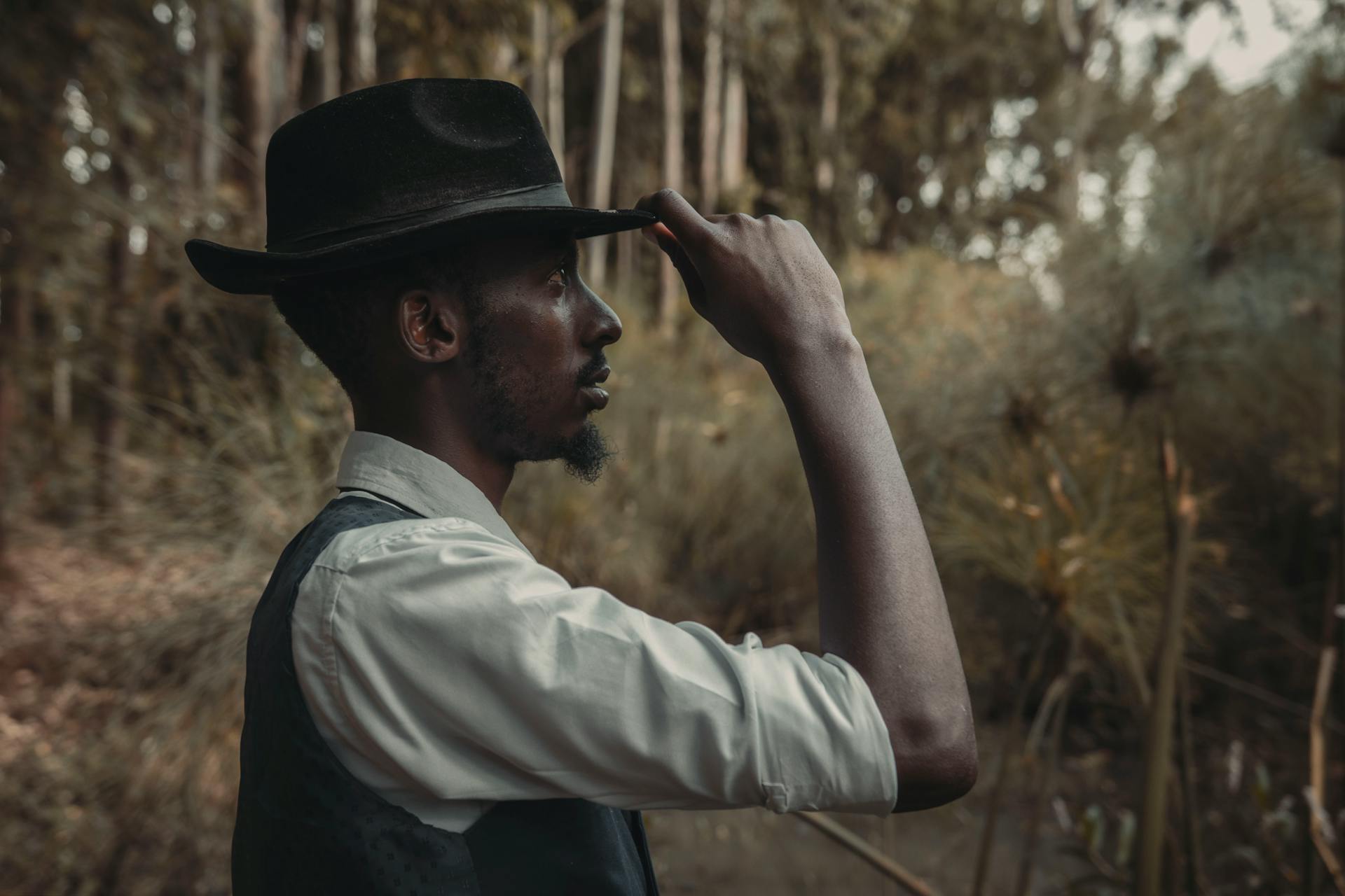 Man Holding Fedora Hat on Head