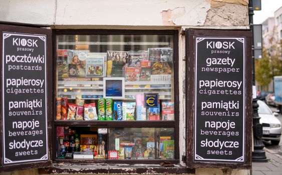 Colorful newsstand in Warsaw featuring magazines, snacks, and beverages.
