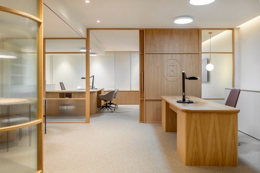 Sleek modern office with wooden furniture in Barcelona, featuring bright lighting and open space.