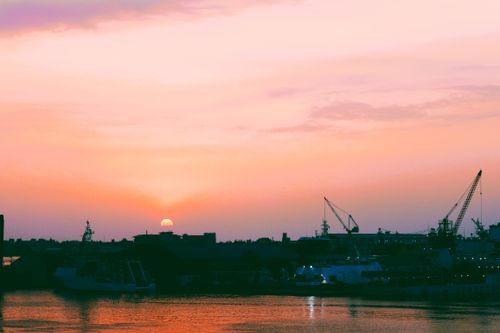 Free Beautiful sunset over a harbor in Taiwan with silhouettes of cranes and ships. Stock Photo