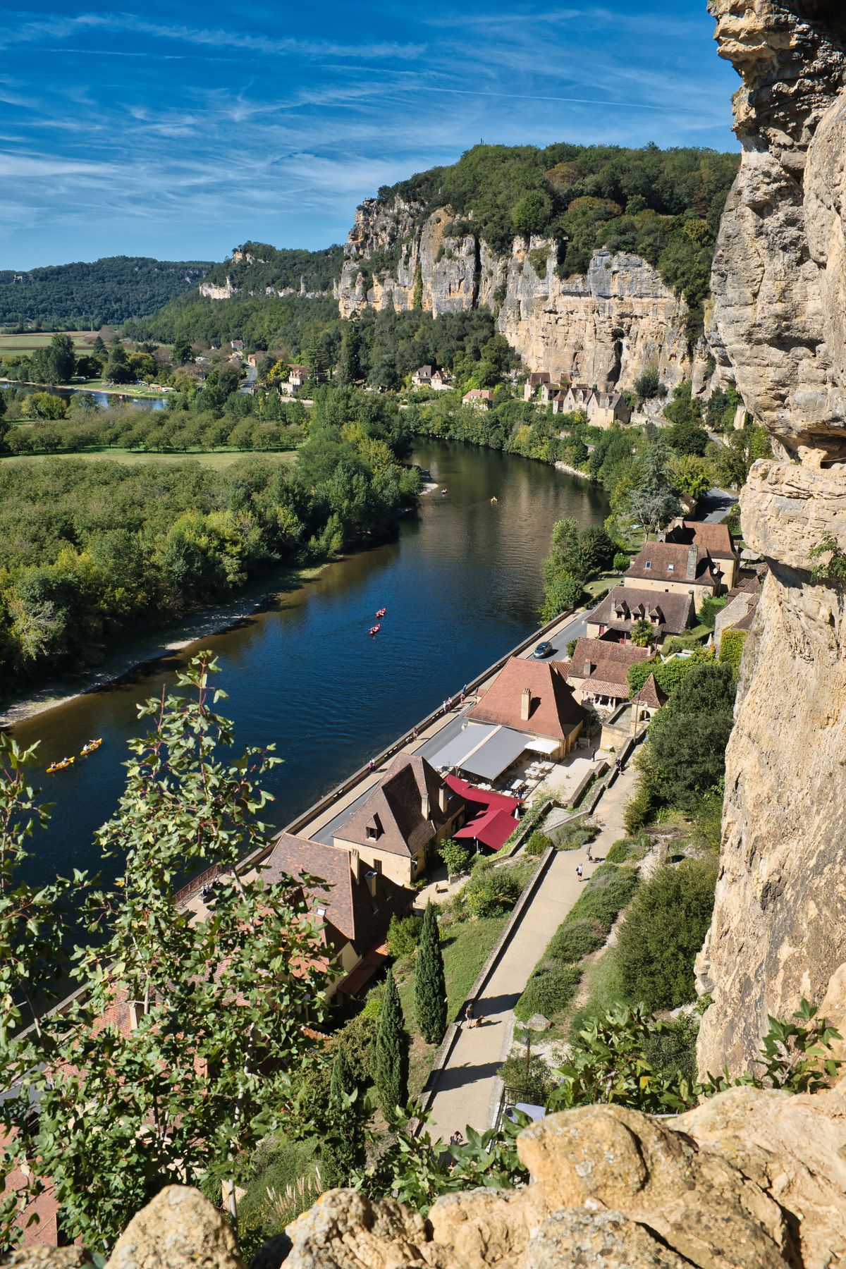Canoes on the green Dordogne between golden cliffs