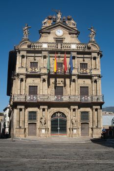 The ornate facade of Pamplona's City Hall, showcasing beautiful architectural details in a sunny plaza.