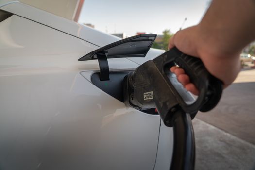 Close-up of electric car being charged, highlighting eco-friendly transportation.