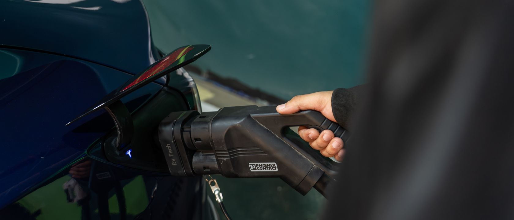 Close-up of an electric vehicle being charged at a station.