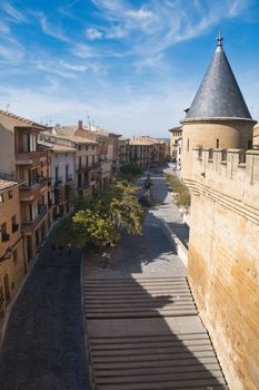 Charming European street with medieval architecture under a vibrant blue sky, showcasing a serene atmosphere.