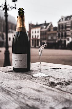 荷兰城市广场的木桌上，放着香槟瓶和碎玻璃