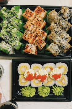 Colorful sushi platter featuring various rolls with garnish and sauces, perfect for culinary inspiration.