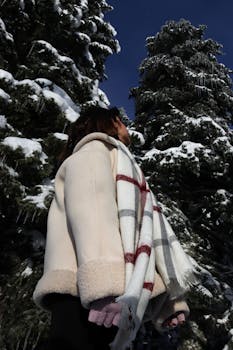 Person in cozy winter outfit among snow-covered trees in Türkiye.