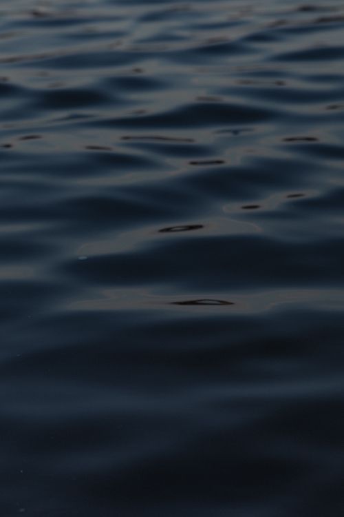 Free Moody ocean waves captured at night in London, showcasing a dark and calming aquatic pattern. Stock Photo