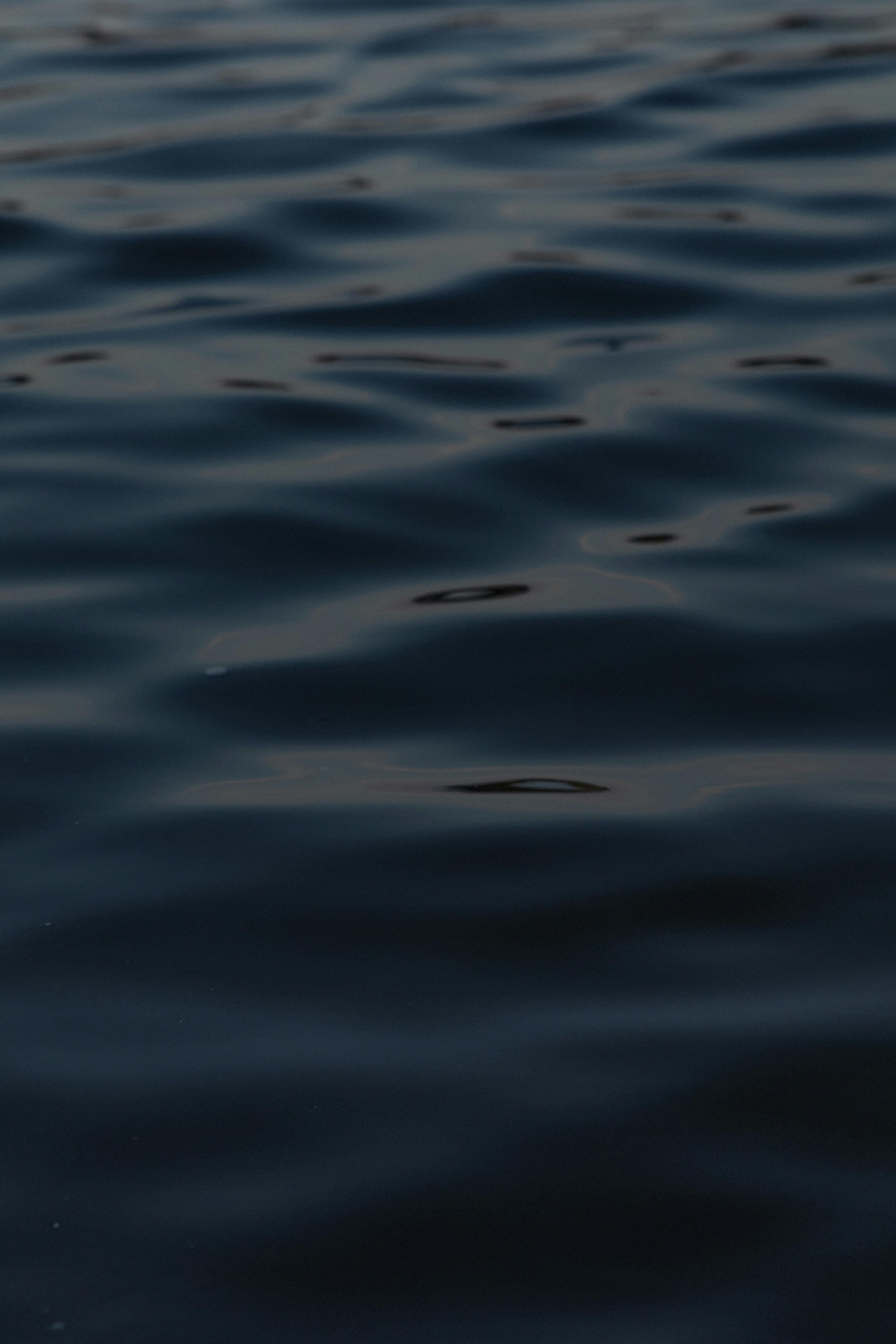 grátis Ondas oceânicas melancólicas capturadas à noite em Londres, exibindo um padrão aquático escuro e relaxante. Foto profissional