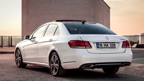 Free Rear view of a white Mercedes-Benz sedan captured outdoors at sunset in Bursa, Turkey. Stock Photo