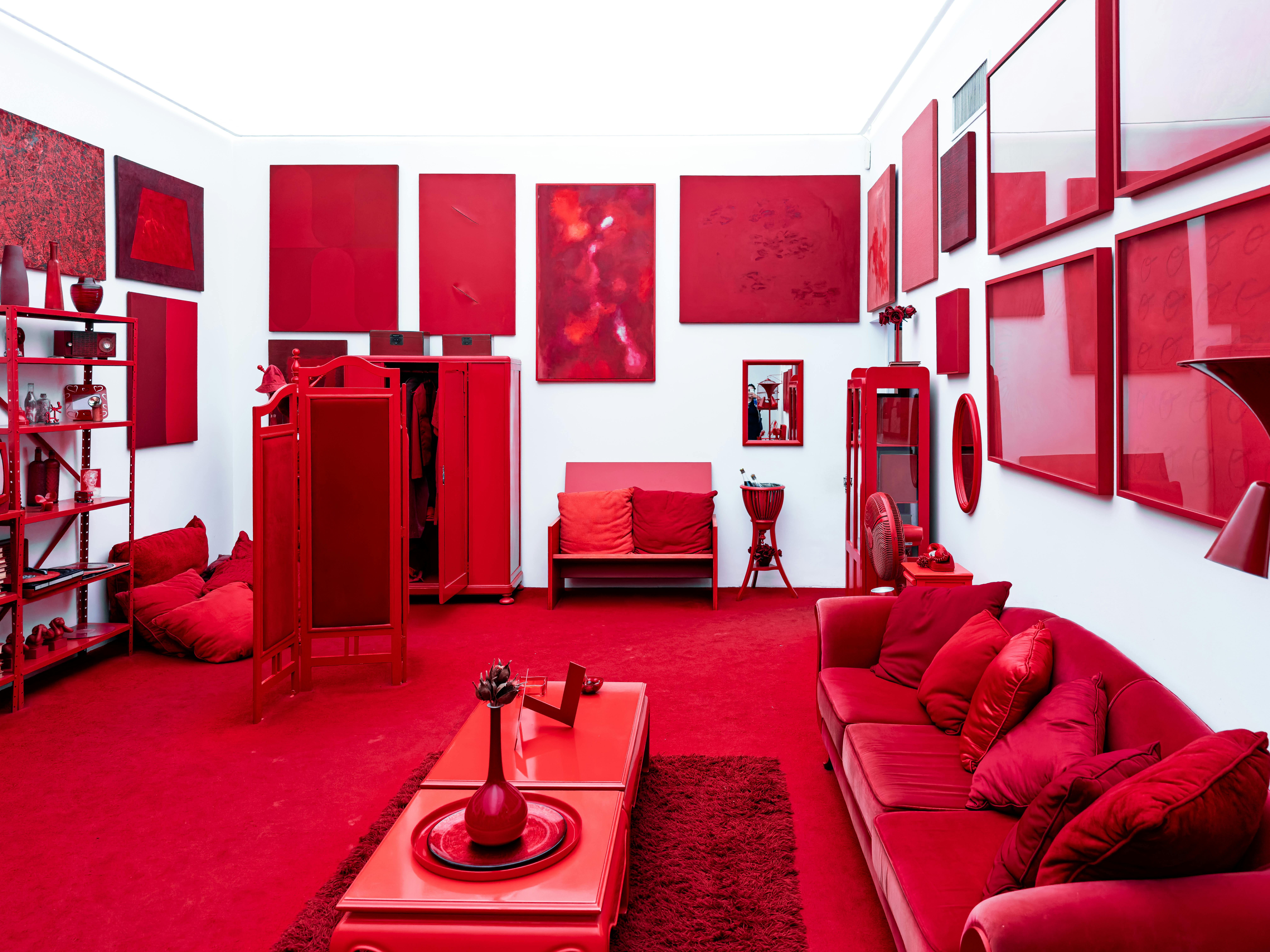 A striking red-themed room featuring modern art pieces and furniture, creating a bold visual impact.