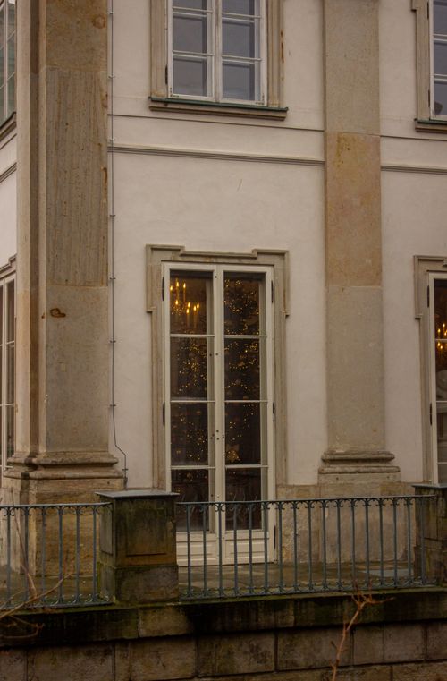 Free A classic Warsaw building facade with festive lights visible through the window. Stock Photo