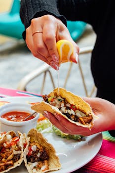 Close-up of tacos with lemon drizzle, served with salsa in Cuenca, Ecuador.