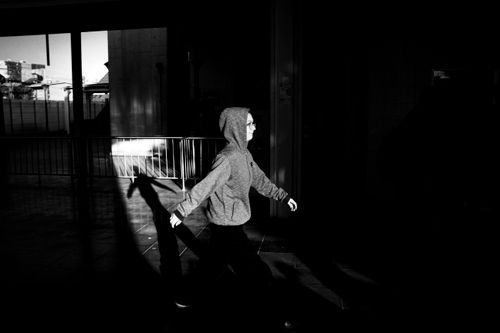 Free Dynamic black and white photo of a person walking with shadows highlighting motion. Stock Photo