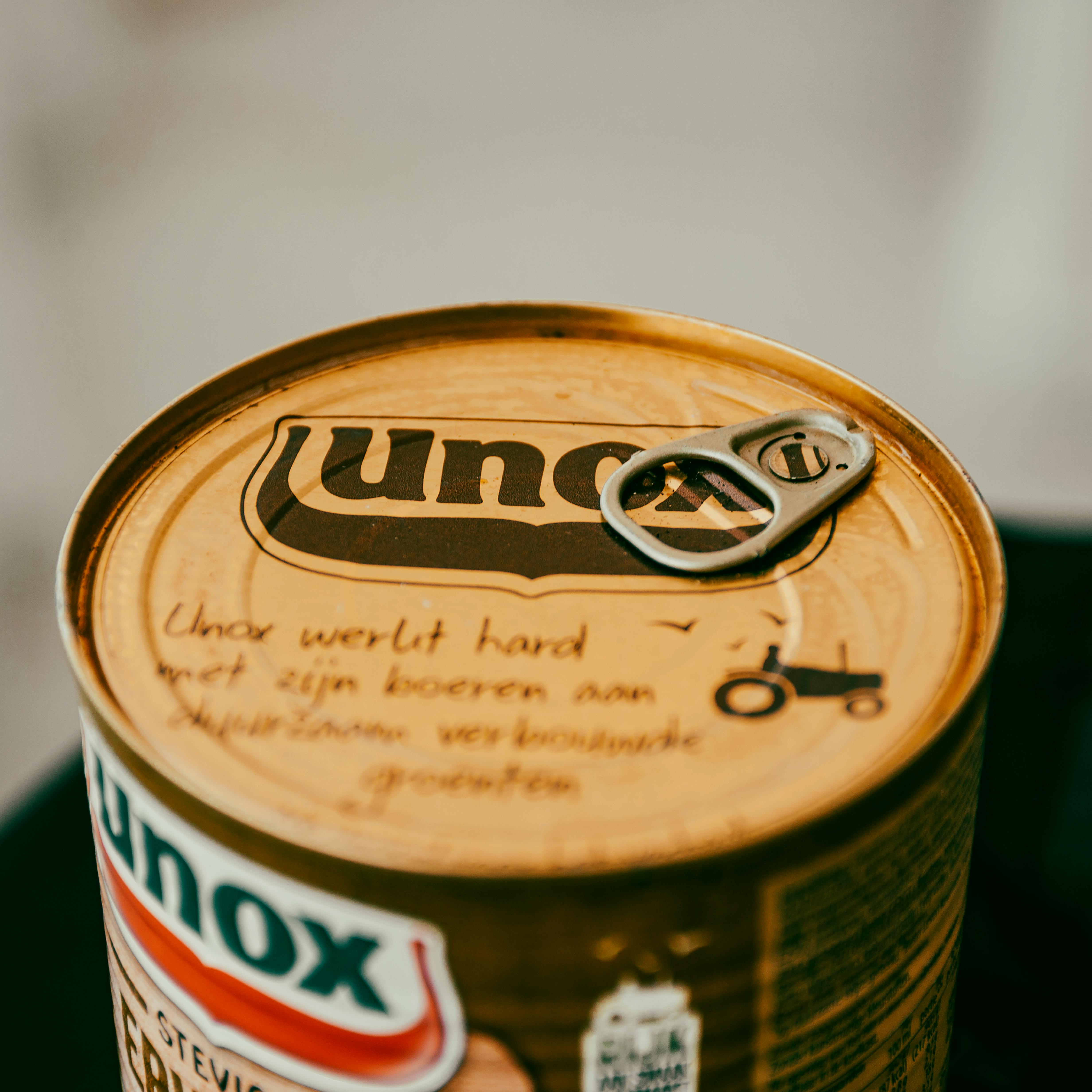 High-quality image of a Unox product can showcasing branding and pull tab in warm tones.