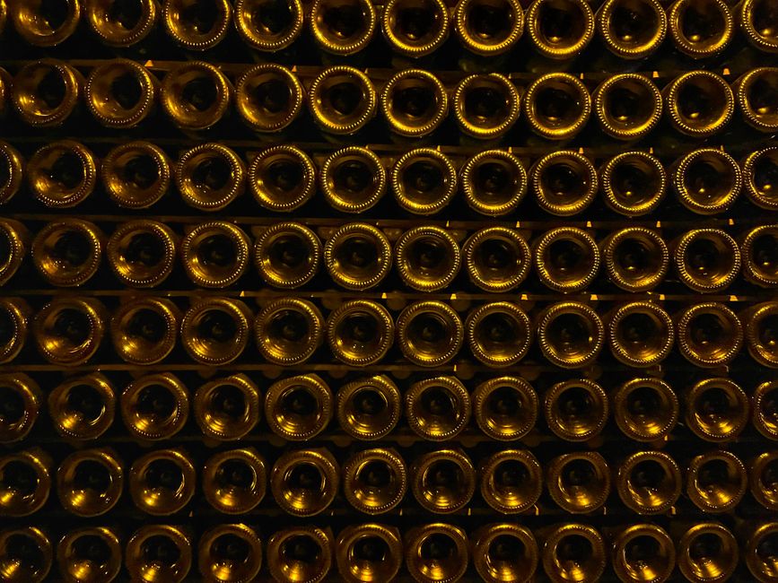 Screw-capped wine bottles beside a bottle of sparkling wine