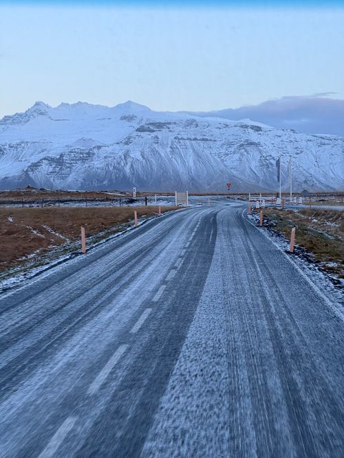 Free Scenic winter landscape of an icy road approaching Icelandic mountains. Stock Photo