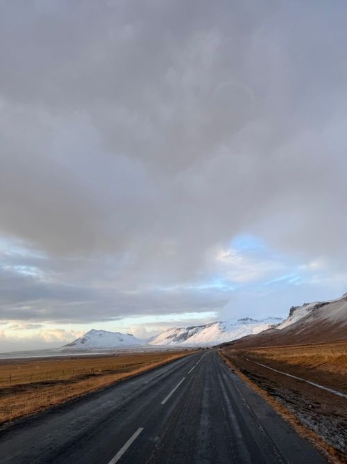 Free A winter landscape of an empty road leading through snow-capped mountains in Iceland. Stock Photo